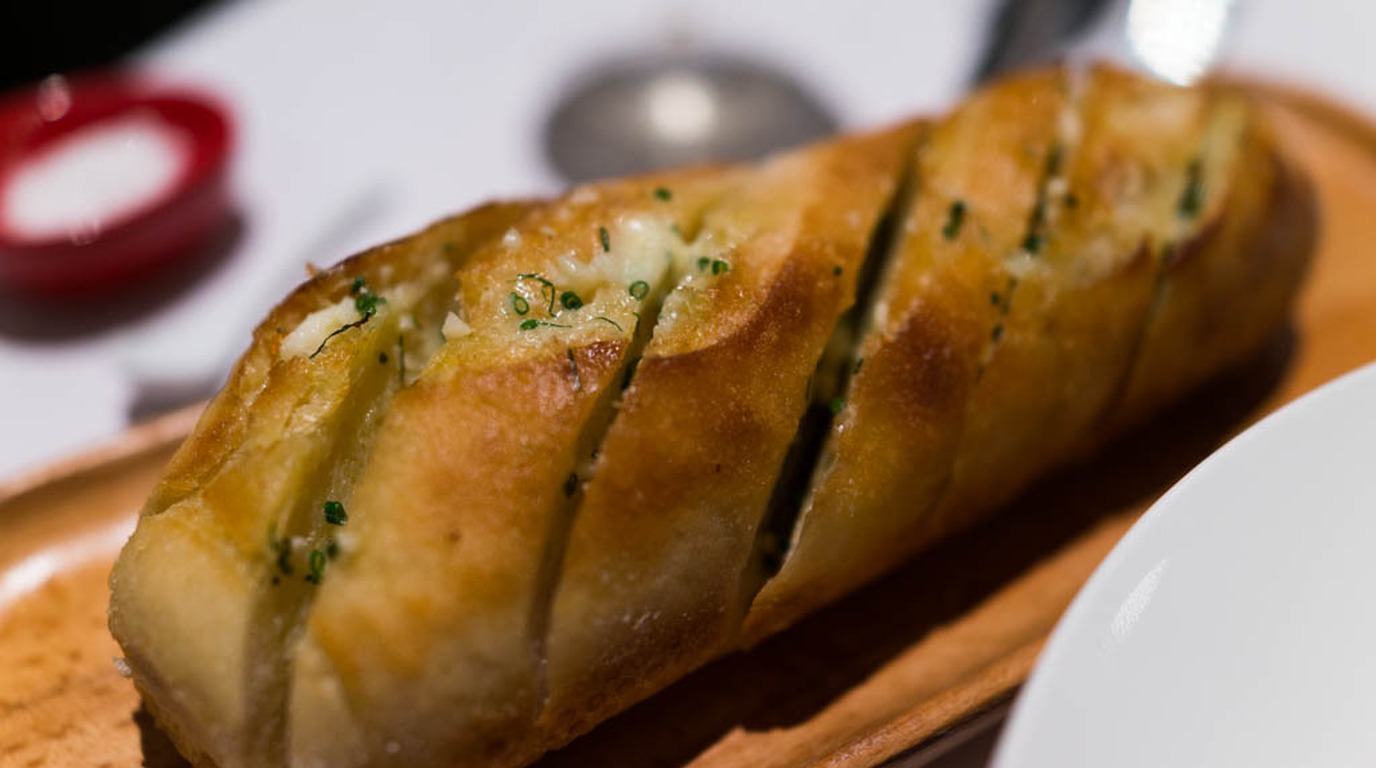 Rustic artisan herb bread boule infused with rosemary and roasted garlic