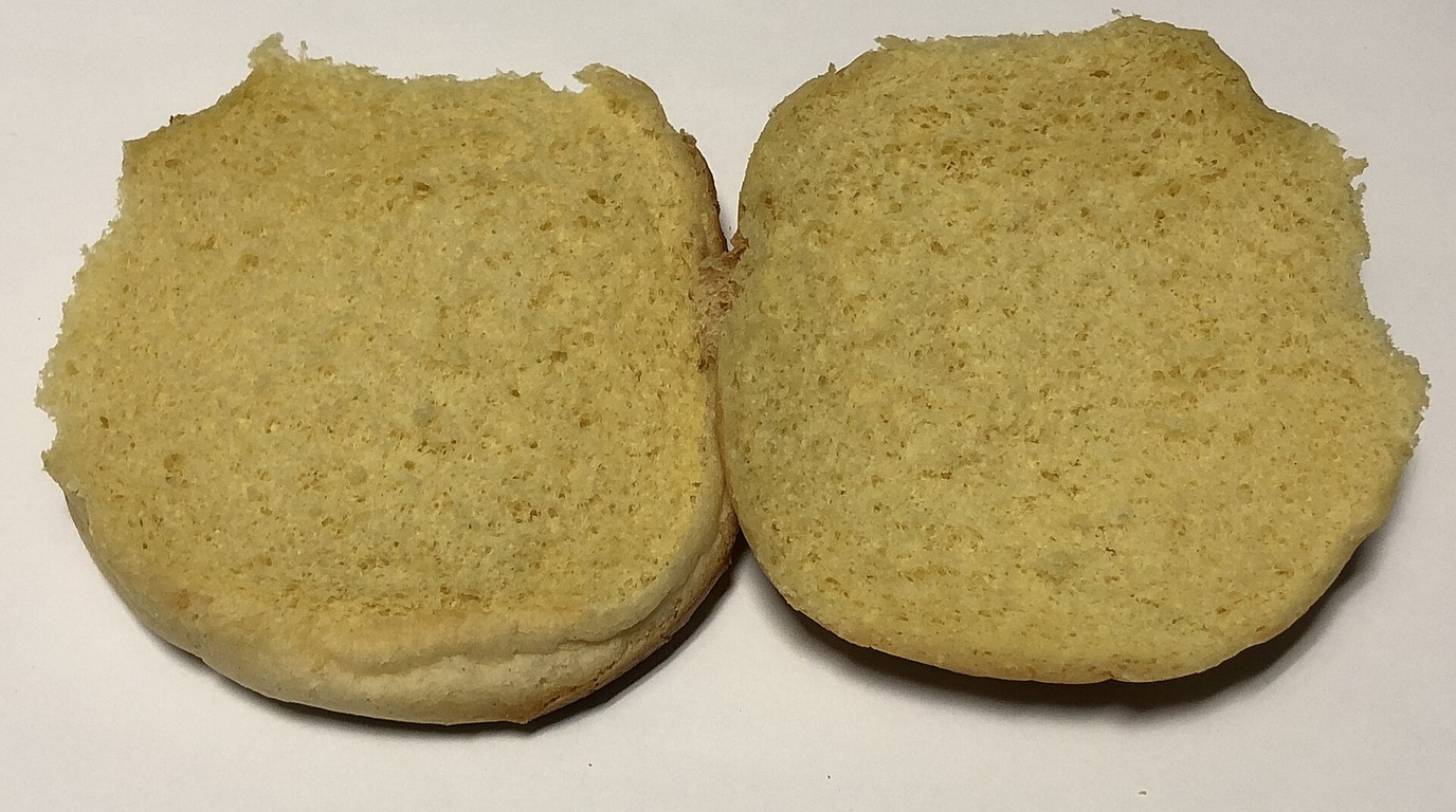 Domed golden bakery-style hamburger buns topped with sesame seeds